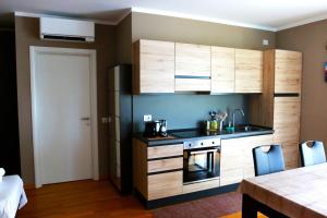 a kitchen with wooden cabinets and a stove at Bnbook - Metropolitan Expo Flat in Rho