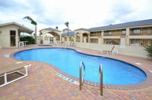 a large swimming pool in front of a hotel at Americas Best Value Inn & Suites San Benito in San Benito