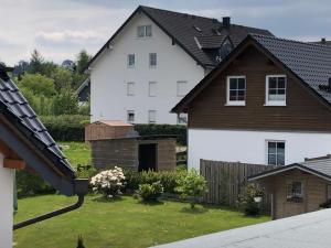 een wit huis met een bruin dak bij Ferienwohnung La Vita in Winterberg