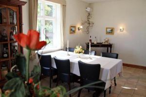 Motel Højmølle Kro في Eskilstrup: غرفة طعام مع طاولة بيضاء وكراسي