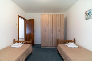 a room with two beds and a wooden cabinet at House Gorica in Bar