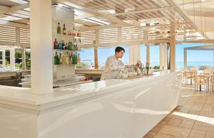 a chef standing at a bar in a restaurant at Capovaticano Resort Thalasso Spa in Capo Vaticano