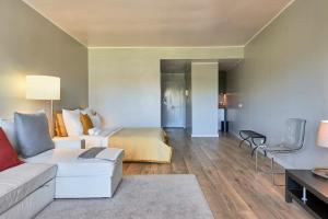 BEACHFRONT Cascais,Estoril Apartment في استوريل: غرفة معيشة مع سرير وأريكة