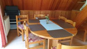 einen Holztisch und Stühle in einem Zimmer mit einem Tisch und einem Chairsktop in der Unterkunft Ferienhaus Nr. 40 im Ferienpark am Twistesee in Bad Arolsen
