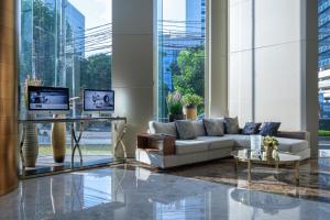 a living room with a couch and a table at Ashley Wahid Hasyim Jakarta in Jakarta