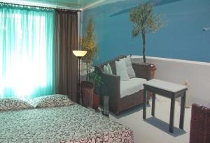 een slaapkamer met een bed en een stoel en een boom bij Apartment on Pyrohova 25 in Vinnytsya