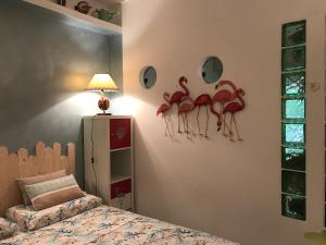 1 dormitorio con flamencos rojos en la pared en Casa Micheletti, en Rodia