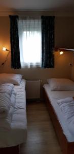 two beds in a room with a window at De Zeeuwse Lûûkjes 2 in Baarland