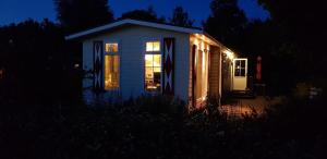 een klein wit huis met lichten in het donker bij De Zeeuwse Lûûkjes 2 in Baarland
