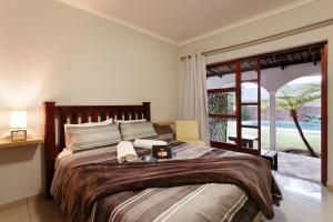 a bedroom with a large bed and a large window at Menlyn Apartments in Pretoria