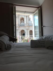 a bed in a room with a view of the building at Casa dei Giurati in Palazzolo Acreide