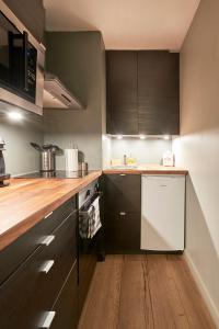 a kitchen with black cabinets and a white dishwasher at Cascais-Estoril BEACHFRONT Apartments in Estoril