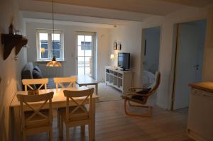 a living room with a table and chairs and a television at Svendlundgaard Apartments in Herning