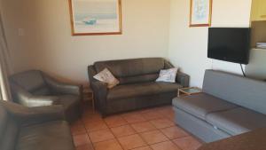sala de estar con 2 sofás y TV en Blue Horizon Flat 8, en Jeffreys Bay