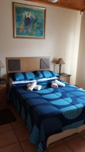 a bedroom with a blue bed with blue and white sheets at Blue Horizon Flat 8 in Jeffreys Bay