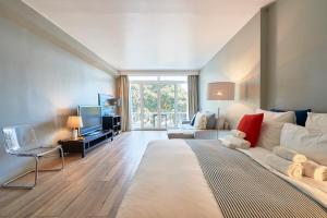 ein Schlafzimmer mit einem großen Bett und ein Wohnzimmer in der Unterkunft Cascais-Estoril BEACHFRONT Apartments in Estoril