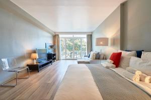 a bedroom with a large bed and a living room at Cascais-Estoril BEACHFRONT Apartments in Estoril