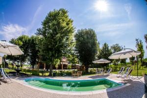 卡奧萊的住宿－Agriturismo Ca' Alleata，庭院内带椅子和遮阳伞的游泳池