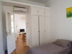 1 dormitorio con armarios blancos, 1 cama y 1 mesa en Silencioso departamento antiguo en Buenos Aires