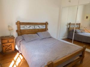 Schlafzimmer mit einem Bett mit einem Kopfteil aus Holz in der Unterkunft Silencioso departamento antiguo in Buenos Aires