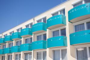 a facade of a building with blue balconies at Victory Gästehaus Therme Erding in Erding