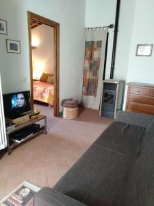 uma sala de estar com um sofá e uma televisão em Casa Vacanze "Nonna Vela" em Petroio