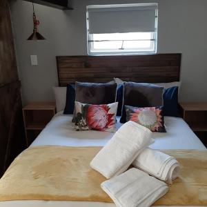 a bedroom with a bed with pillows and a window at Oppermans Villa in Pretoria