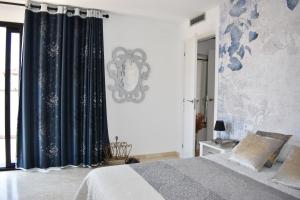 a bedroom with a bed and a black curtain at SUNSET PENTHOUSE SITGES in Sitges