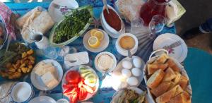 una tavola blu ricoperta di piatti di alimenti e uova di Camp'in Goris a Goris