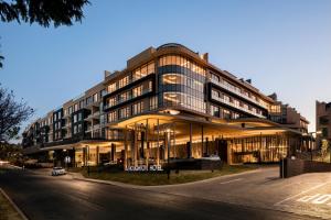 um grande edifício ao lado de uma rua em The Houghton Hotel, Spa, Wellness & Golf em Joanesburgo