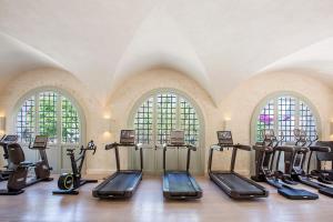 a gym with treadmills and ellipticals in a room with windows at Borgo Egnazia in Savelletri di Fasano