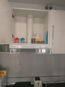 eine Küche mit einem Regal über einer Theke mit einem Weinglas in der Unterkunft Viviendas Turísticas La Merced in Ronda