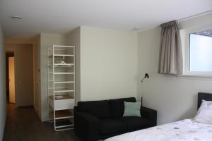 - une chambre avec un lit et un canapé noir dans l'établissement Bed & Breakfast Op 't Leven, à Ermelo