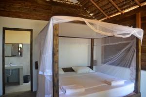 a bed with a canopy in a room at Arne's Place in Arugam Bay