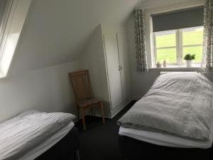 a bedroom with a bed and a window and a chair at Bed & Breakfast v/Pia Sørensen in Fredericia