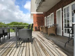 a wooden deck with chairs and tables on a house at Bed & Breakfast v/Pia Sørensen in Fredericia