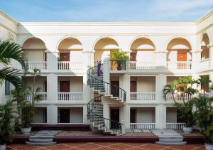 a building with a spiral staircase in a courtyard at Avani Hai Phong Harbour View Hotel in Hai Phong