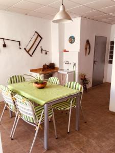 una mesa y sillas en una cocina con mesa verde en La casita Santa Bárbara, en Macastre