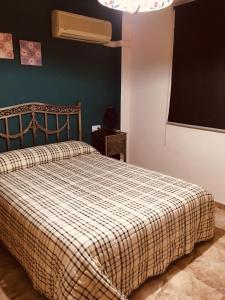a bedroom with a bed with a checkered blanket at La casita Santa Bárbara in Macastre