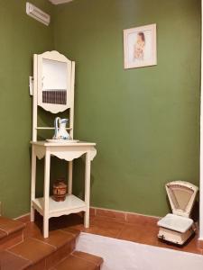a green room with a white shelf and a mirror at La casita Santa Bárbara in Macastre