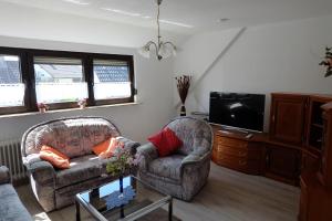 ein Wohnzimmer mit 2 Stühlen und einem TV in der Unterkunft Ferienwohnung in Dierdorf in Dierdorf