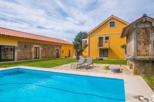 a swimming pool in front of a house at Casas do Prazo - Turismo Rural in Nogueira