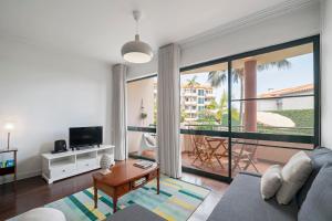 a living room with a couch and a tv at Varandas do Funchal II by An Island Apart in Funchal
