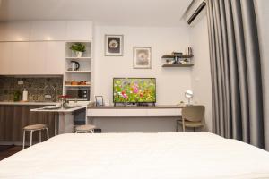 a bedroom with a bed and a desk with a television at A Cosy Apartment in Vinhomes Green Bay Ha Noi in Hanoi
