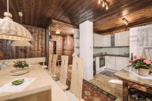 Berghütte Hochpillberg في Pill: مطبخ وغرفة طعام مع وألواح خشبية