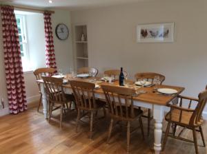 jadalnia z dużym drewnianym stołem i krzesłami w obiekcie Brandoch Lodge w mieście Logierait