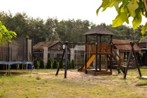 a playground with a slide and a swing set at Садиба «Під ліском» in Pulʼmo