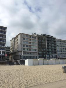 a building on the beach next to a sandy beach at Rustig, kindvriendelijk appartement in Ostend