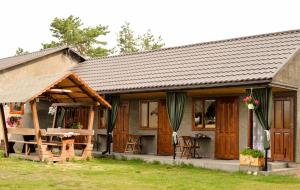 a small house with wooden doors and windows at Садиба «Під ліском» in Pulʼmo