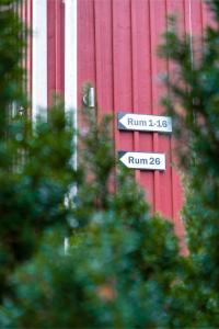 a street sign in front of a red building at EttSmart Hotell in Sollentuna